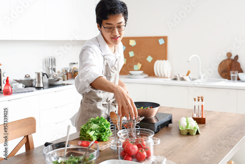Young Asian man frying vege...