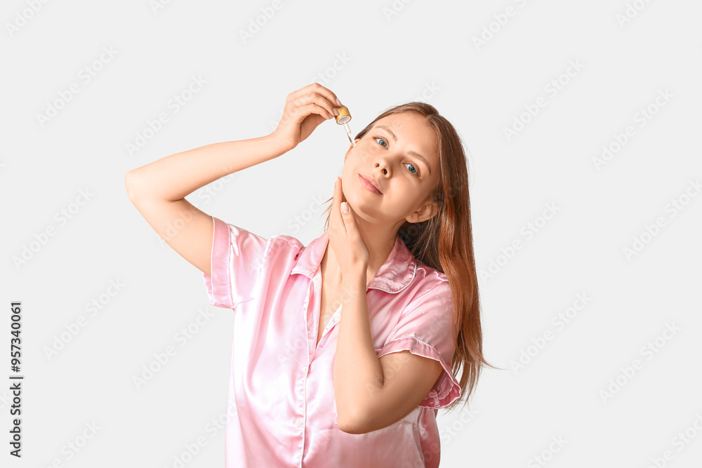Pretty young woman with cosmetic oil on light background Pretty young woman with cosmetic oil on light background