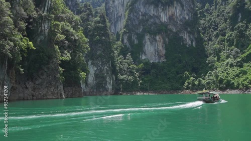 tourists travel on traditional Thai longtail boat for sightseeing in Ratchaprapha Dam or Cheow Lan reservoir in Surat Thani province, Thailand. photo