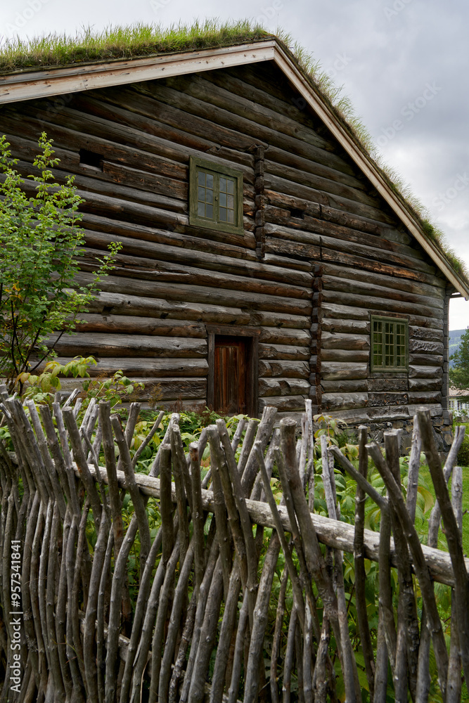 Spacious and Historic Traditional Log House from Norway with Intricate Braided Wooden Fence, Set in a Scenic Rural Landscape Spacious and Historic Traditional Log House from Norway with Intricate Braided Wooden Fence, Set in a Scenic Rural Landscape
