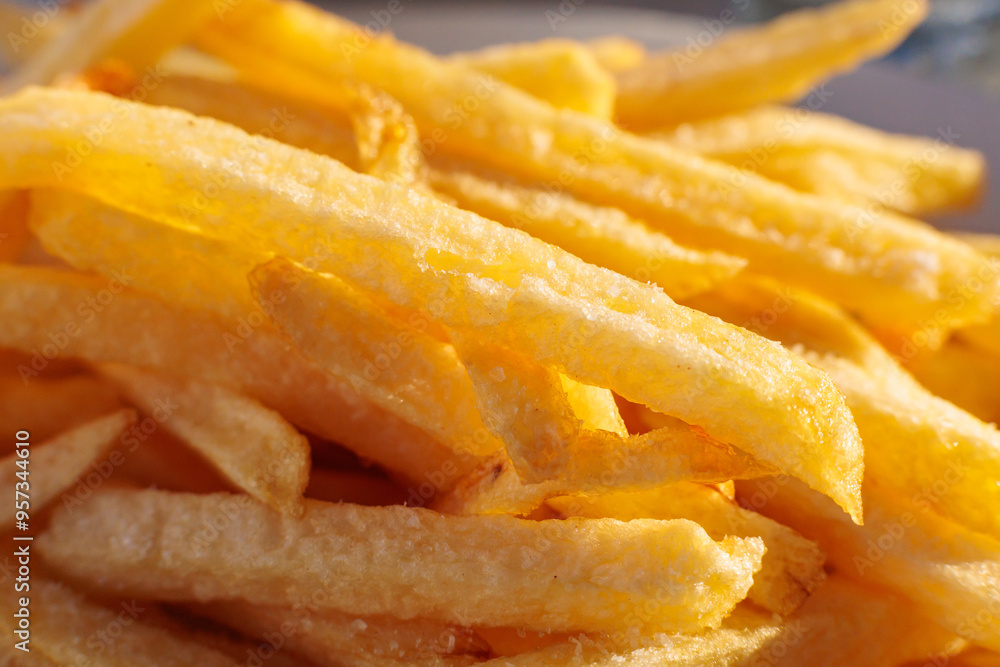 Crispy golden French fries served in a casual outdoor setting during a sunny afternoon Crispy golden French fries served in a casual outdoor setting during a sunny afternoon