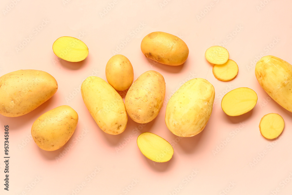 Obraz premium Cut and whole raw potatoes on pink background