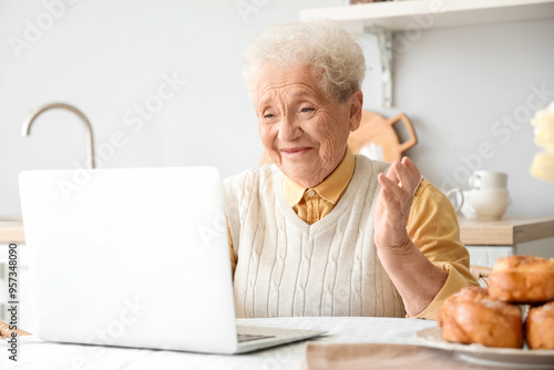 Senior woman using laptop a...