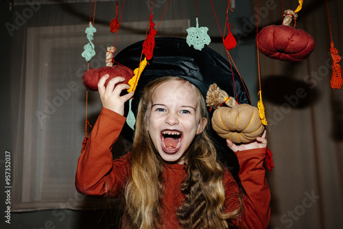 Girl with spooky face among halloween-themed decorations