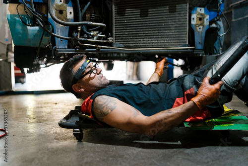 Mechanic Repairing Vehicle Undercarriage photo