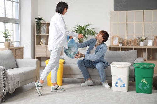 Young couple with garbage c...