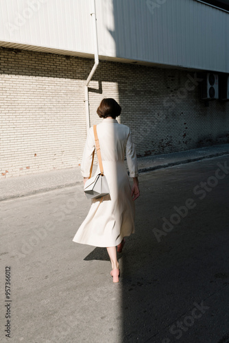 Woman Walking in Urban Alley in Daylight