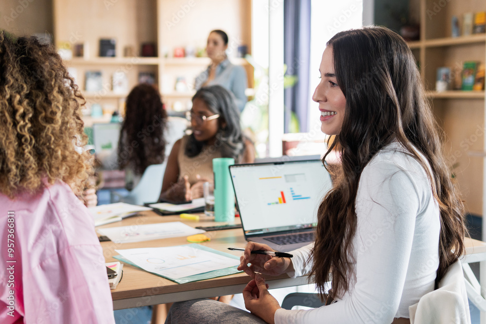 Portrait of a woman in an office conversing with her colleague. Portrait of a woman in an office conversing with her colleague.