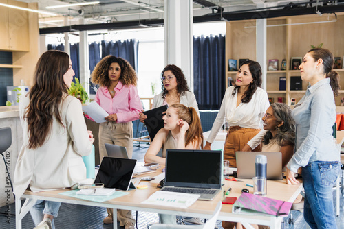 Woman leading a group of women in an office. photo