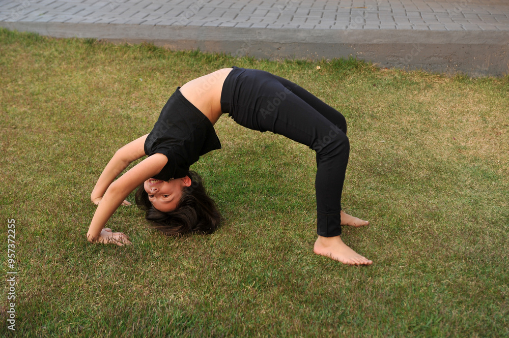 Fototapeta premium menina fazendo exercicios ponte na grama 