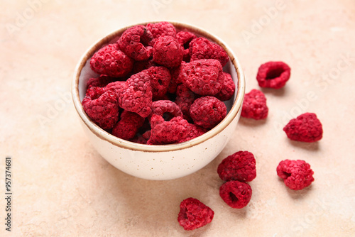 Fotografie Bowl of dehydrated raspberries on beige background