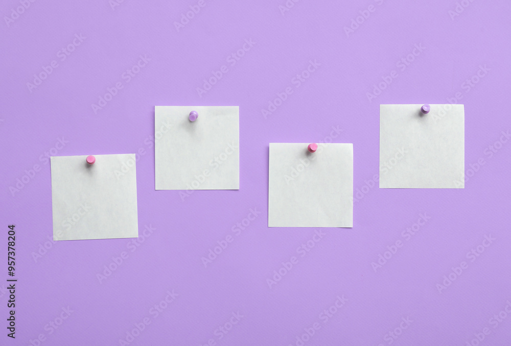 Paper notes pinned on lilac background Paper notes pinned on lilac background