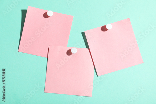 Pink paper notes pinned on turquoise background