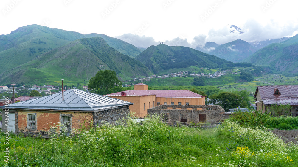 Panoramic view from the grassy hill on the Kazbek mountains and the green valley Panoramic view from the grassy hill on the Kazbek mountains and the green valley