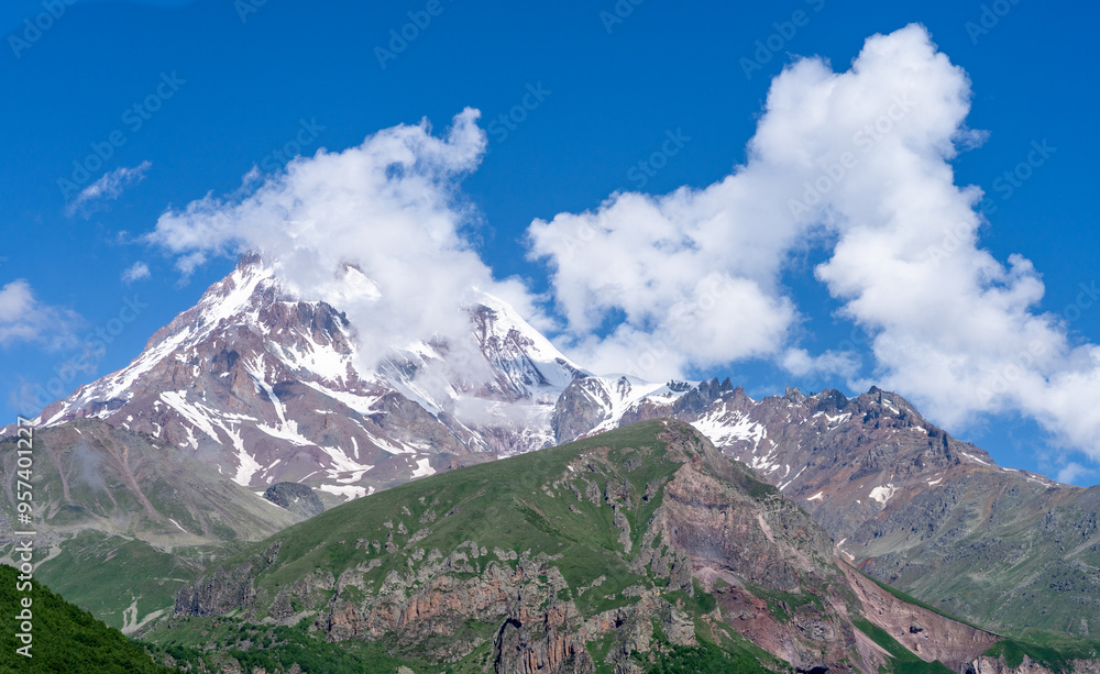 Fototapeta premium Panoramic view from the grassy hill on the Kazbek mountains and the green valley