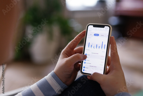 Uncecognizable woman looking through diagrams in banking application