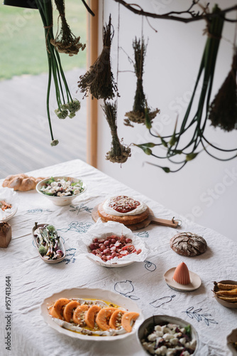 Table with various dishes and hanging herbs with sunlight photo