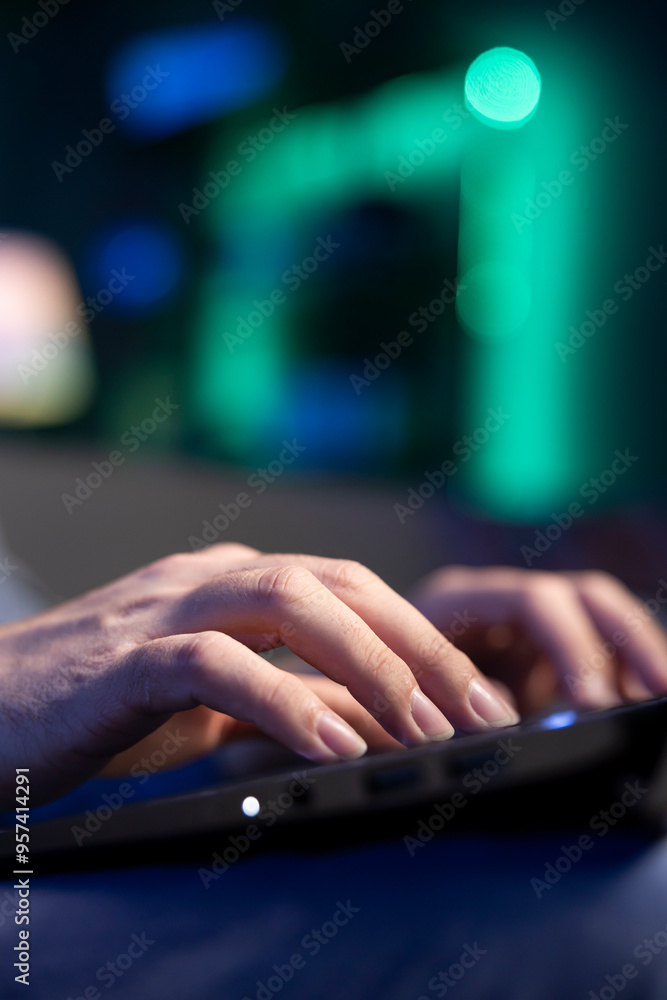 Close up shot of laptop used by teleworker lying on couch, remotely performing tasks in personal home office. Focus on notebook used by man in blurry background inputting data Close up shot of laptop used by teleworker lying on couch, remotely performing tasks in personal home office. Focus on notebook used by man in blurry background inputting data