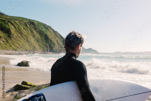 An expert surfer concentrating to enter the sea to train surfing photo