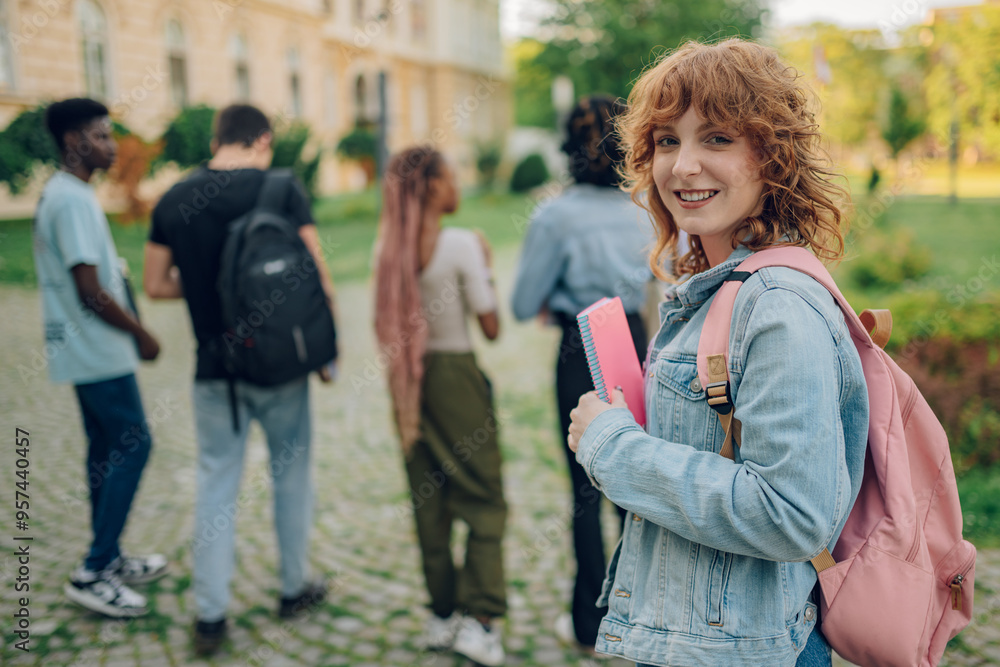 Fototapeta premium Close up of ginger female university student at campus smiling at camera