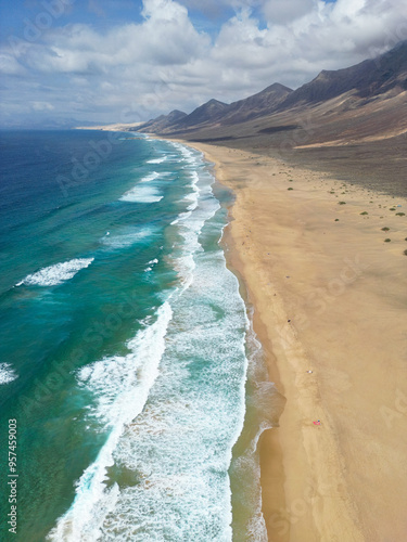 Obraz na płótnie Słynna, piękna, naturalna plaża Fuerteventury Playa de Cofete położona wśród gór. The famous, beautiful, natural beach of Fuerteventura, Playa de Cofete, located among the mountains. w salonie