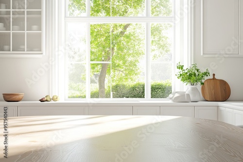 A sunny kitchen with a large window overlooking a lush green garden, featuring a wooden table and an empty countertop.