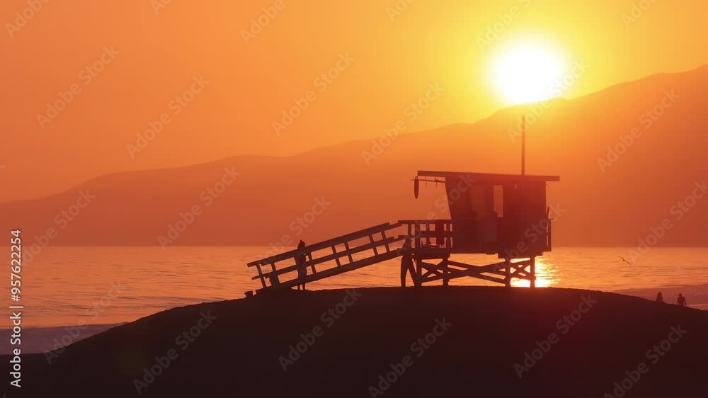Enjoy the stunning aerial view of a lifeguard tower during sunset in Malibu, California. This serene beach scene features a glowing horizon, creating a picturesque and peaceful atmosphere Enjoy the stunning aerial view of a lifeguard tower during sunset in Malibu, California. This serene beach scene features a glowing horizon, creating a picturesque and peaceful atmosphere