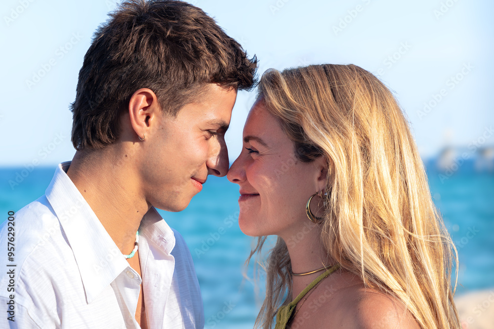 Happy young couple on the beach on vacation looking at each other with love Happy young couple on the beach on vacation looking at each other with love