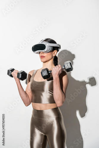 Woman using virtual reality headset while lifting dumbbells indoors photo