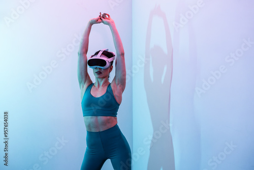 Woman in athletic wear uses VR headset while stretching indoors photo