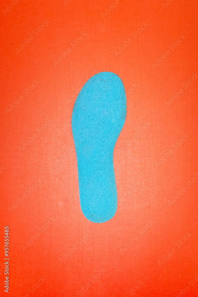 Blue footstep shape on a red background with hard direct flashlight Blue footstep shape on a red background with hard direct flashlight