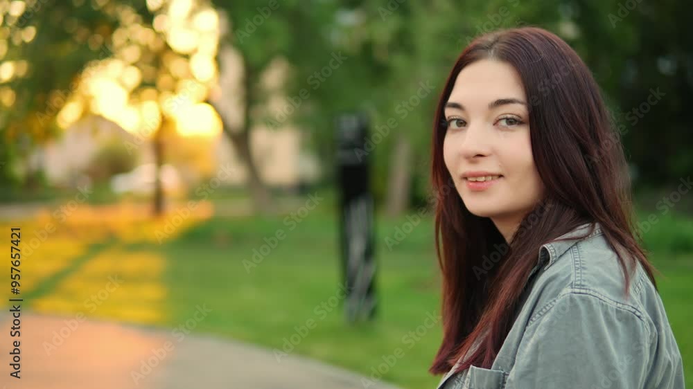 Portrait of attractive young adult Caucasian lady with long dark hair sitting in the park and looking at camera. Pretty woman is resting outdoors and smiling. Walking in town in warm weather theme Portrait of attractive young adult Caucasian lady with long dark hair sitting in the park and looking at camera. Pretty woman is resting outdoors and smiling. Walking in town in warm weather theme