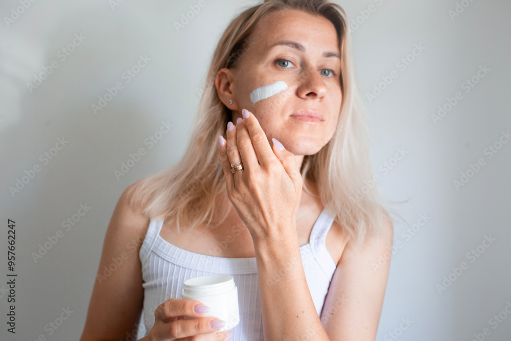 blondy woman applying serum, cream to face blondy woman applying serum, cream to face