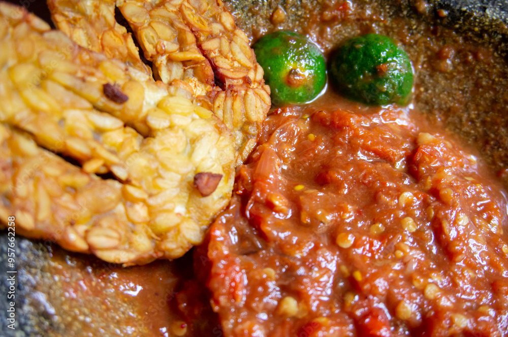Homemade extra spicy chili sauce served in a traditional stone mortar Homemade extra spicy chili sauce served in a traditional stone mortar