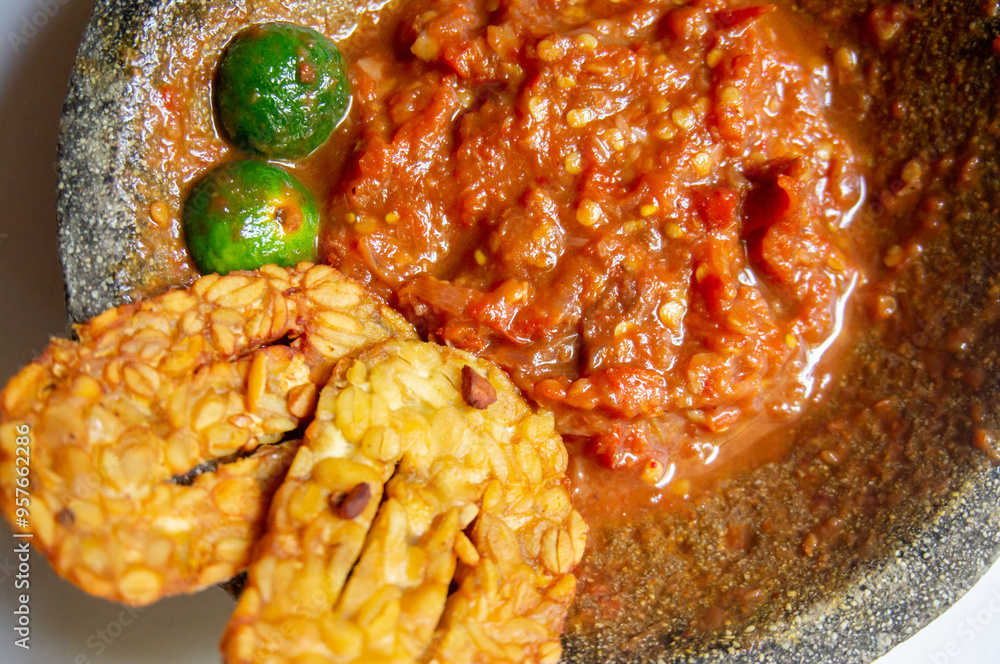 Homemade extra spicy chili sauce served in a traditional stone mortar Homemade extra spicy chili sauce served in a traditional stone mortar
