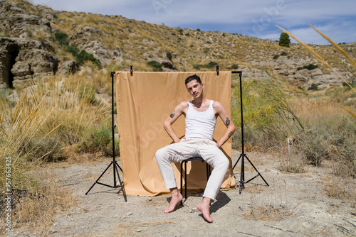 Model posing sitting on stool during photoshoot in nature photo