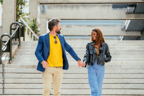 Interracial couple walking hand in hand on urban stairs photo