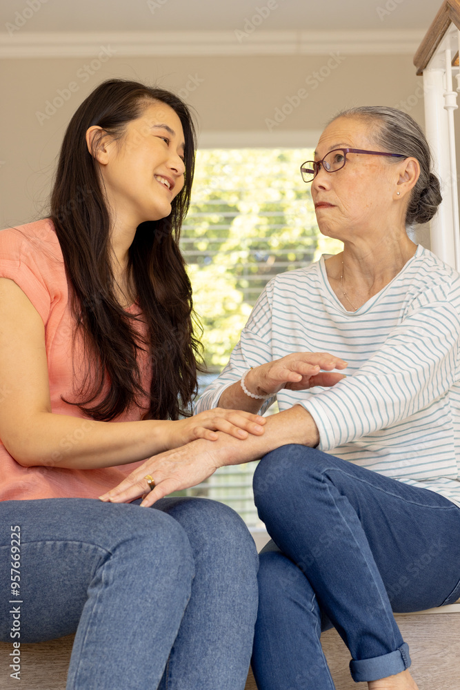 Smiling asian grandmother and granddaughter, holding hands and sitting together Smiling asian grandmother and granddaughter, holding hands and sitting together