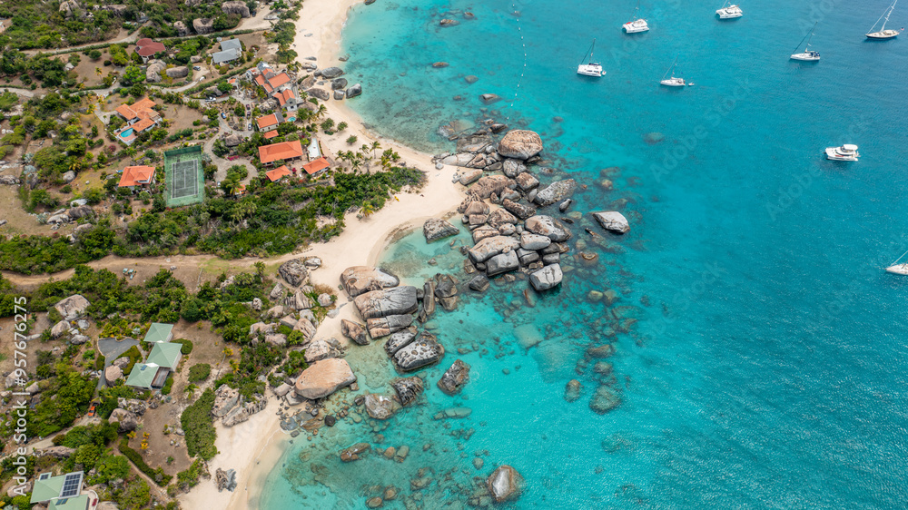 Paradise in BVI - Aerial shot of a luxury beach house with sailboats anchored in the front yard Paradise in BVI - Aerial shot of a luxury beach house with sailboats anchored in the front yard
