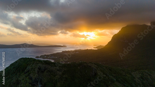 Sunset over Mount Otemanu on tropical island Bora Bora in French Polynesia. Low clouds float above the extinct volcano on the popular tourist destination in the south pacific sea.  photo