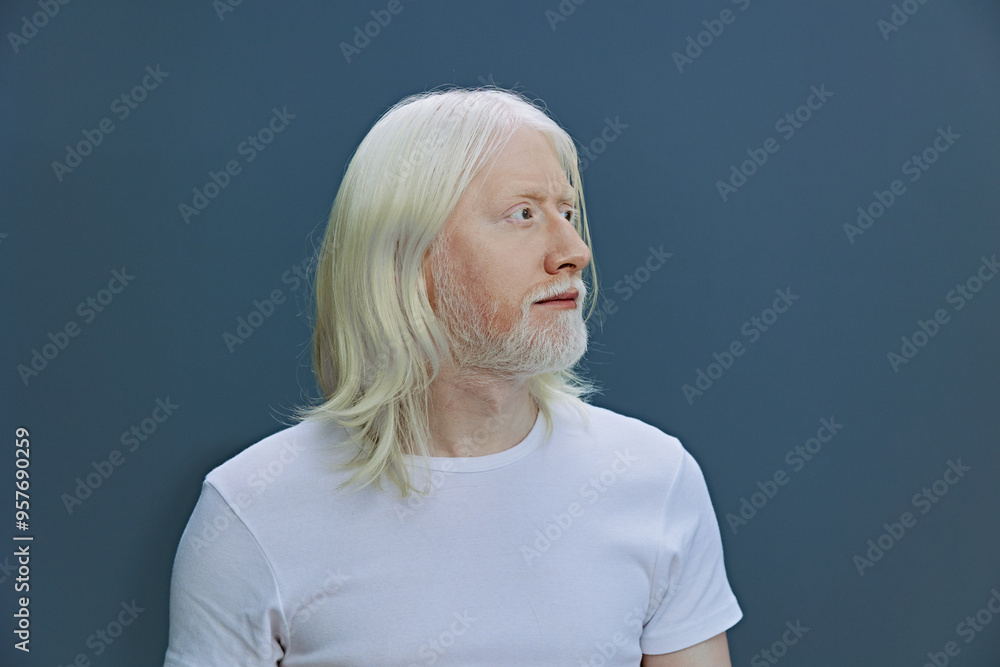 Portrait of a thoughtful man with long white hair and beard, against a solid dark blue background, conveying a sense of introspection and calmness Portrait of a thoughtful man with long white hair and beard, against a solid dark blue background, conveying a sense of introspection and calmness