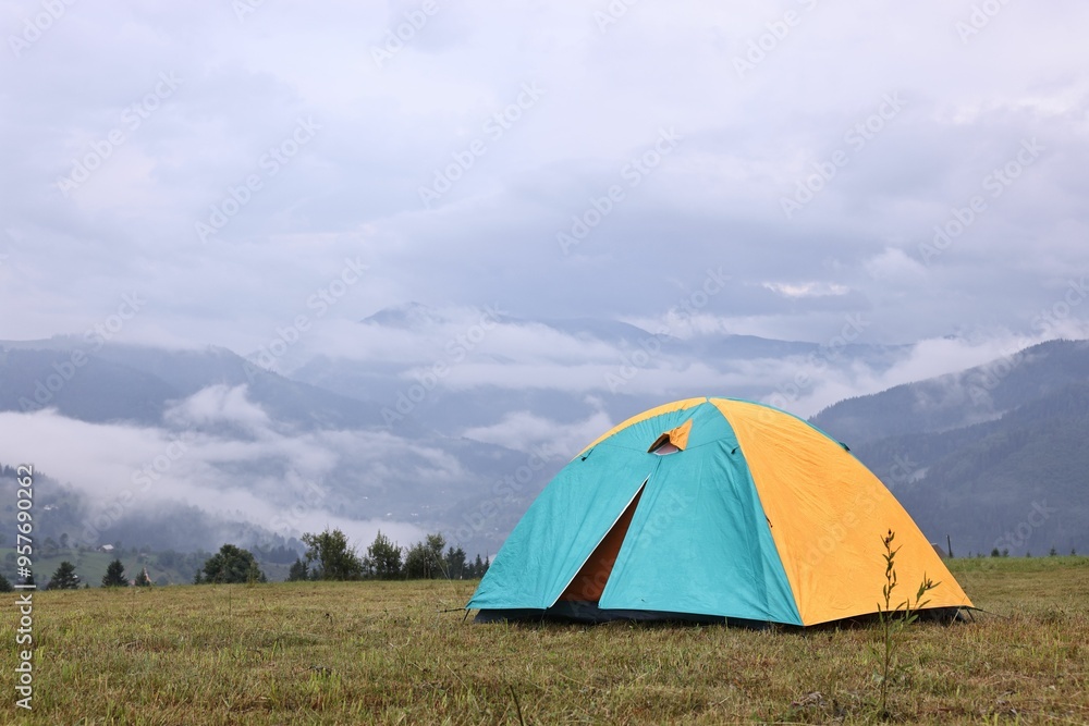 Tent on green grass in mountains, space for text Tent on green grass in mountains, space for text