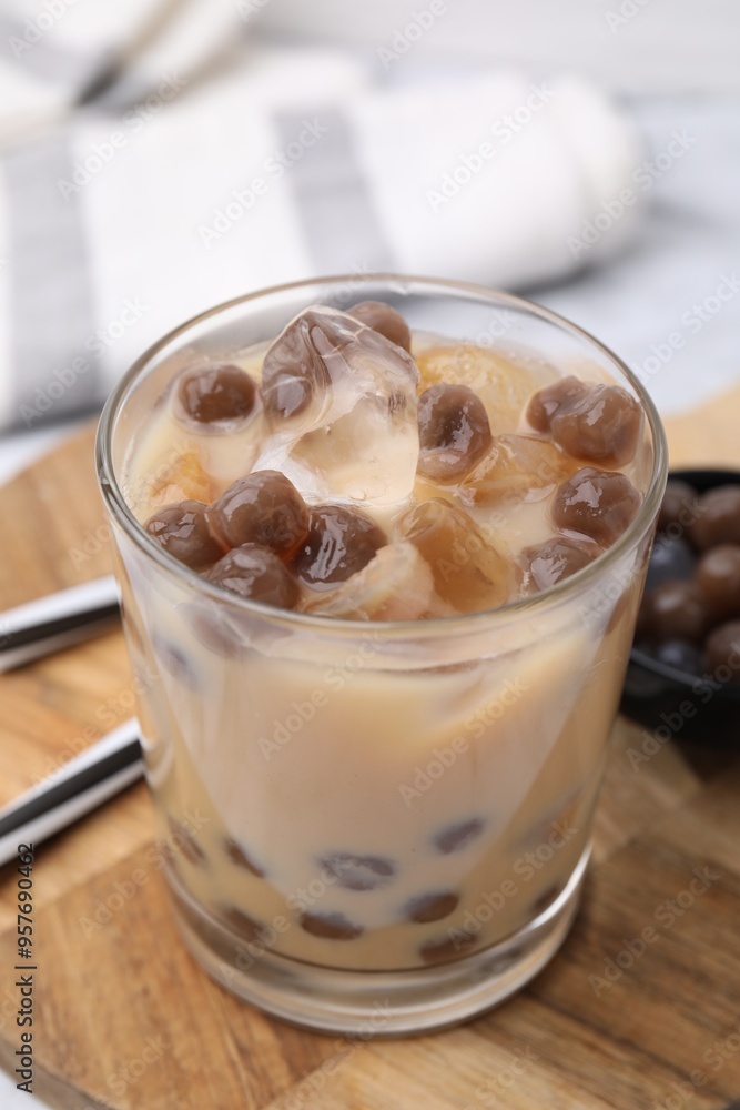 Tasty milk bubble tea in glass, tapioca pearls and straws on table, closeup Tasty milk bubble tea in glass, tapioca pearls and straws on table, closeup
