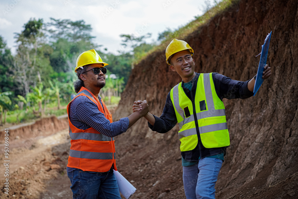 Two construction workers high-five, give thumbs up and shake hands because they have agreed to the work. Two construction workers high-five, give thumbs up and shake hands because they have agreed to the work.