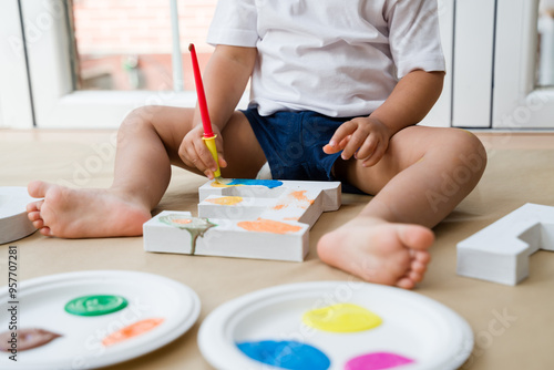 Toddler painting wooden letter e at home photo