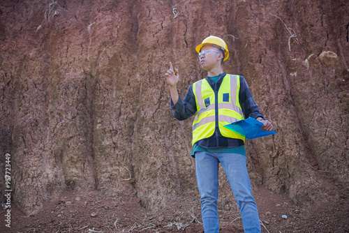 A male construction worker is inspecting and recording data in the field