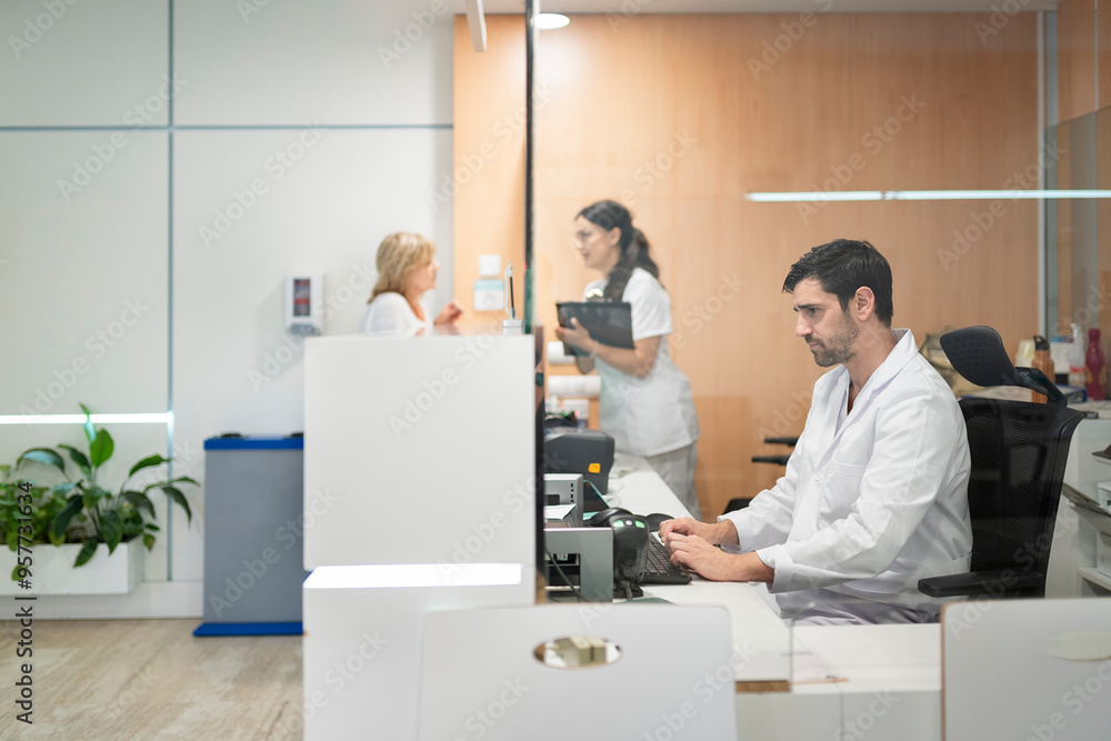 Medical staff working at hospital reception desk Medical staff working at hospital reception desk