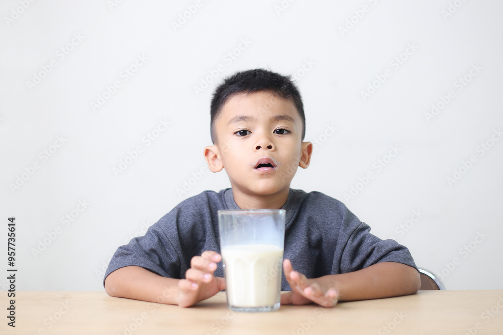 Asian child drinking milk on white background. Smiling of Asian boy with a glass of milk. Asian child drinking milk on white background. Smiling of Asian boy with a glass of milk.