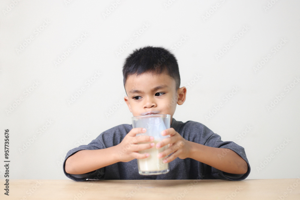 Asian child drinking milk on white background. Smiling of Asian boy with a glass of milk. Asian child drinking milk on white background. Smiling of Asian boy with a glass of milk.