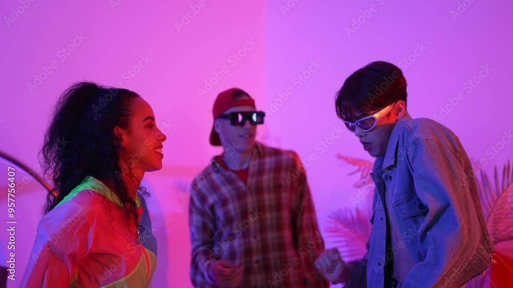 Diverse happy people moving to lively music with neon light at studio. Attractive hipster dancing while asian man show energetic movement while multicultural team cheering and supporting. Regalement. Diverse happy people moving to lively music with neon light at studio. Attractive hipster dancing while asian man show energetic movement while multicultural team cheering and supporting. Regalement.